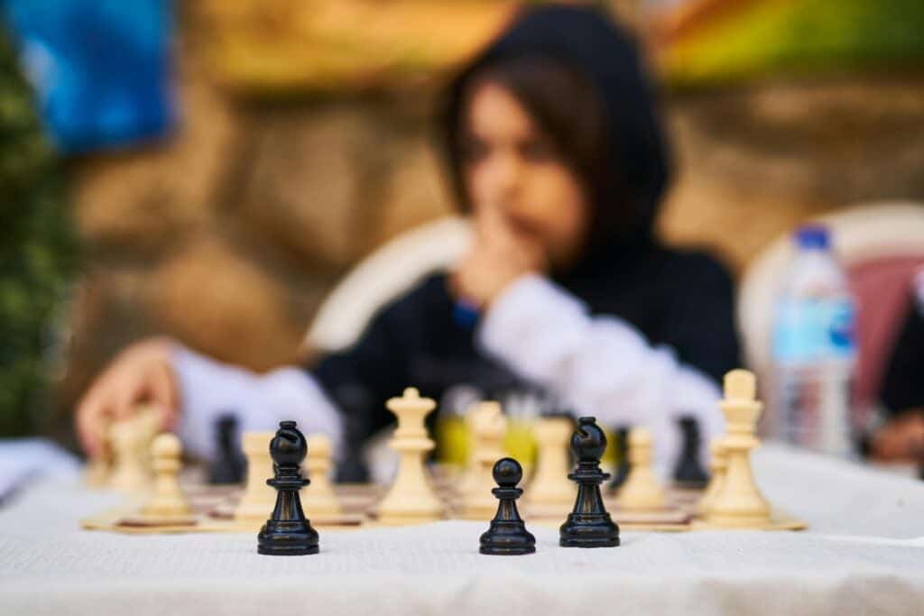 Chess game with person with hood