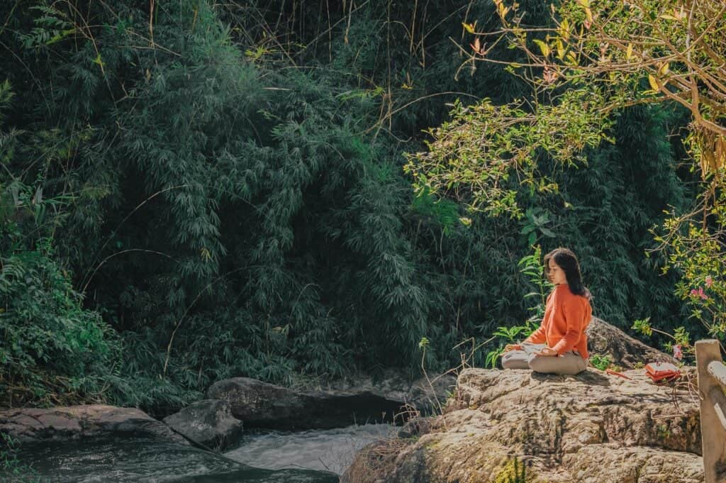 woman meditating in the woods