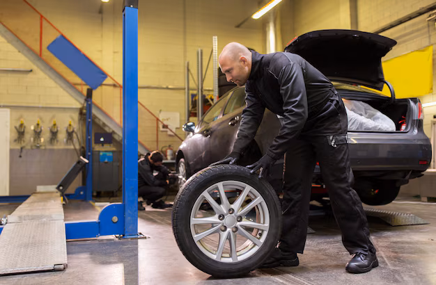 Auto mechanic changing a tire in a workshop
