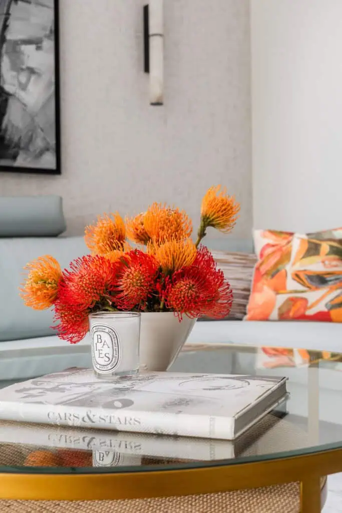 Elegant floral display with vibrant orange and red blooms in a minimalist white vase.