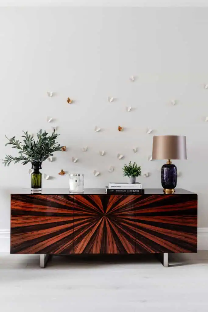 Stylish Victorian refurbishment interior with wooden sideboard, plants, and decorative wall art.