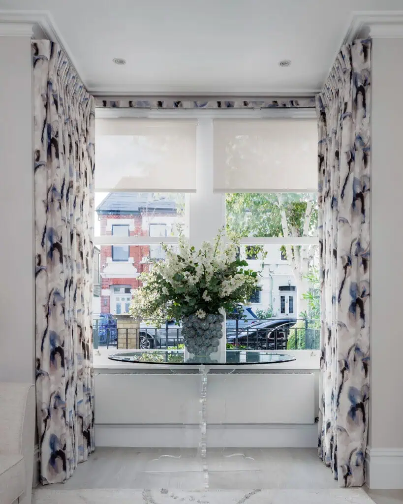 Elegant Victorian-style interior with floral curtains and a central floral arrangement.