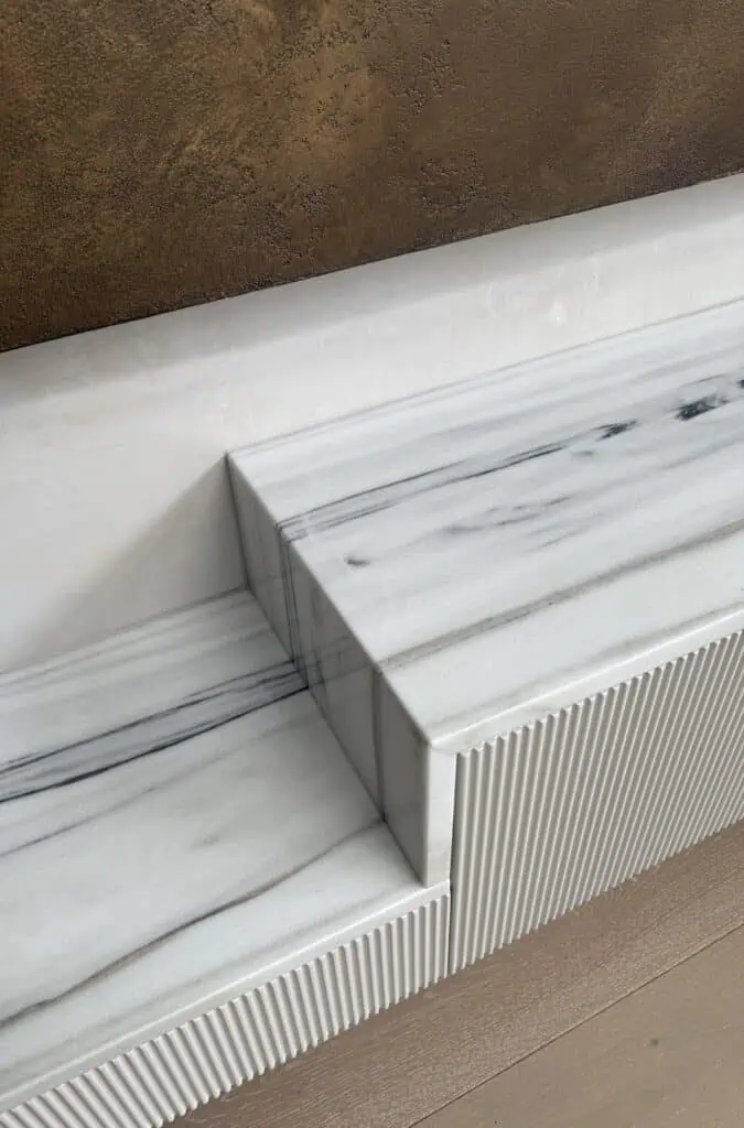 Elegant marble fireplace with textured base in Kew family residence.