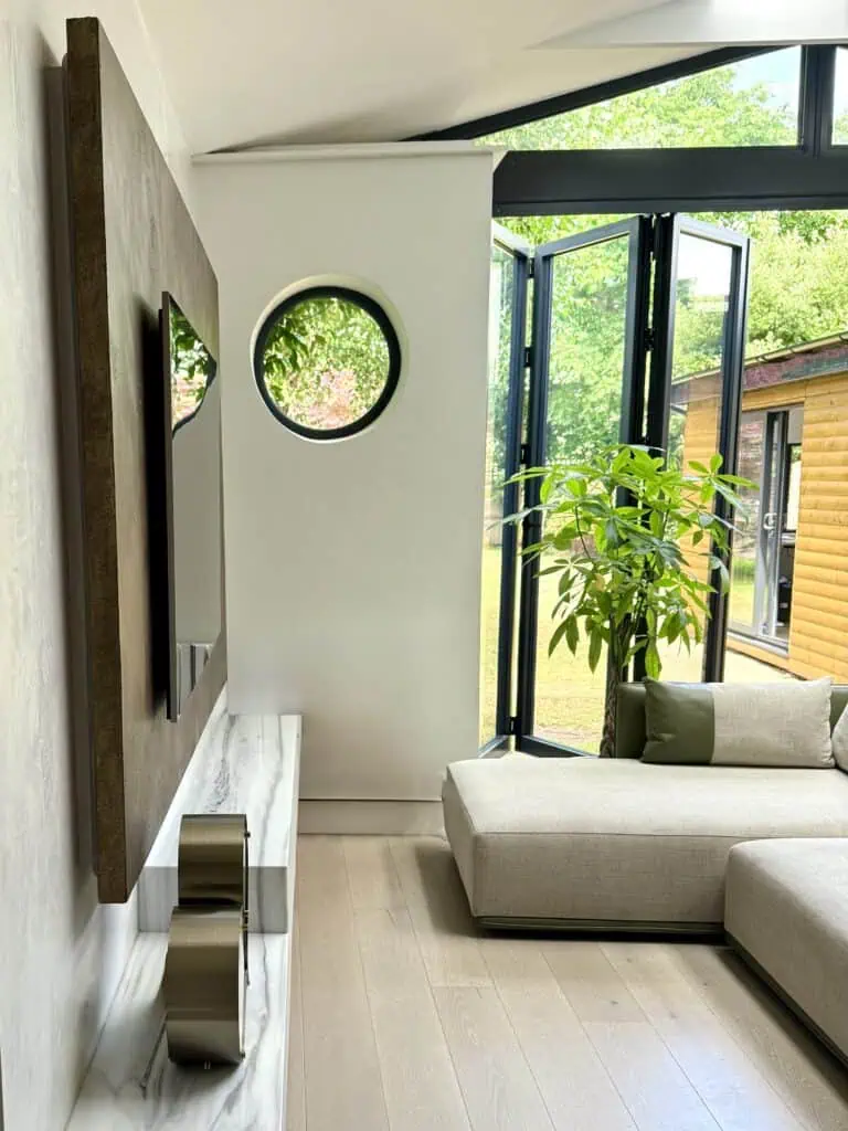 Bright living room with large windows and greenery view.