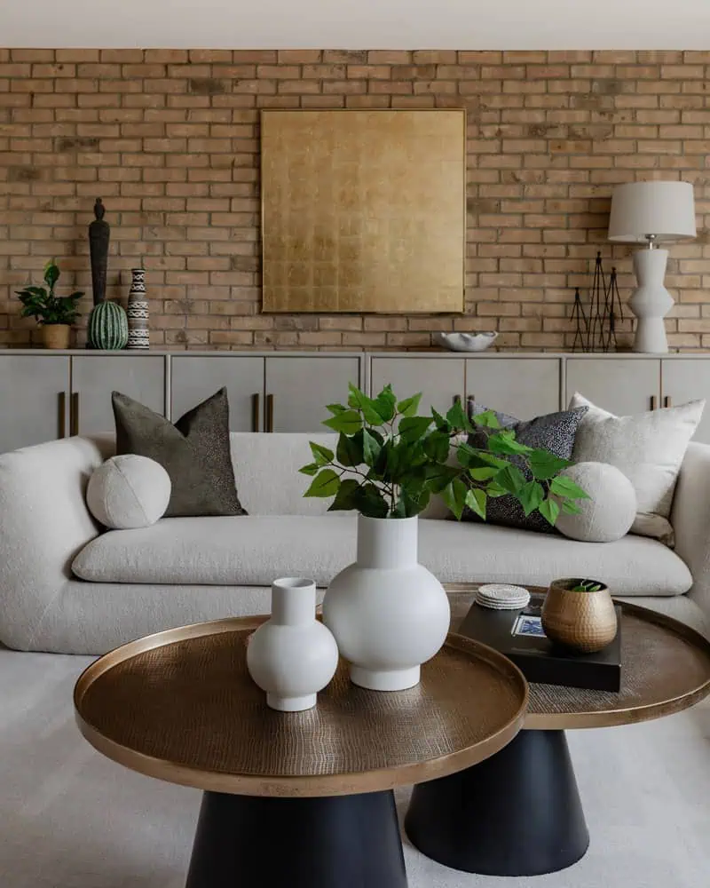 Elegant living room with contemporary decor and exposed brick wall in Wimbledon new build. Stylish,.