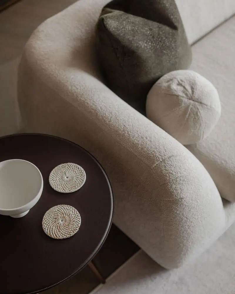 Soft beige and grey cushions on a contemporary sofa in a modern Wimbledon interior design setting.
