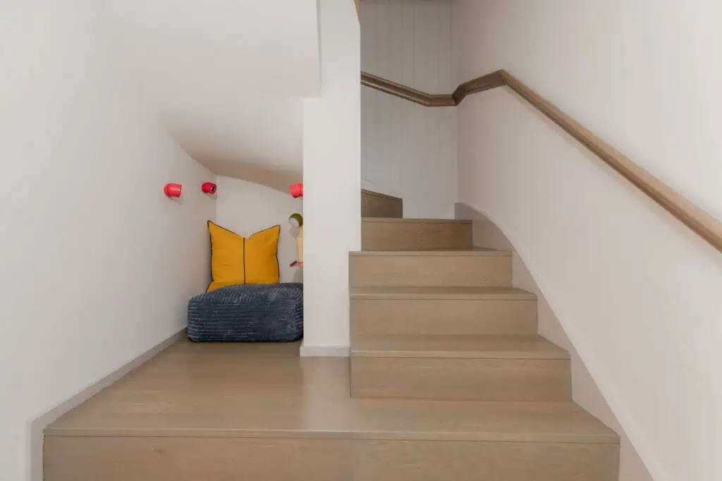 Modern minimalist staircase with cozy nook in Wimbledon contemporary home.