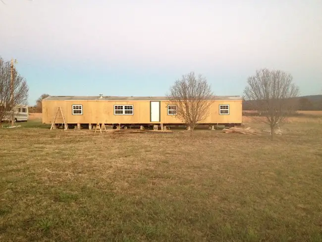 1985 Liberty single wide mobile home exterior during new siding and roofing install