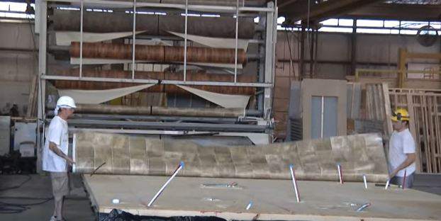 laying vinyl flooring down in manufactured home factory before walls- vinyl tile in manufactured homes