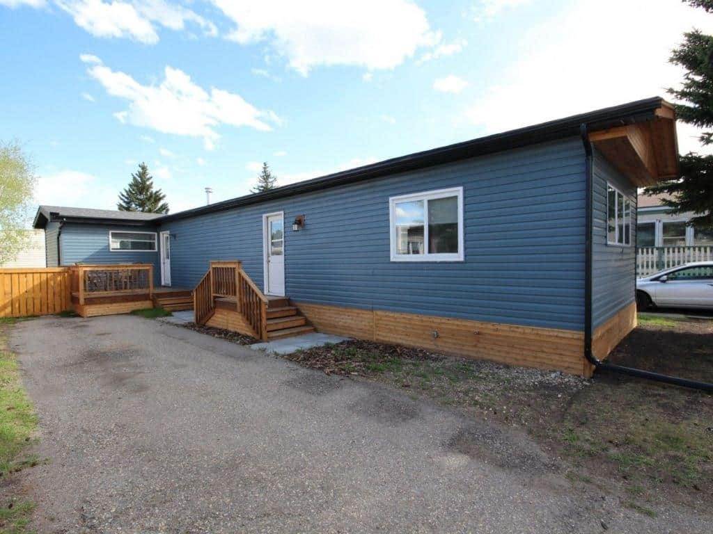 Single wide mobile home with vinyl siding and wood trim