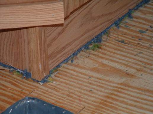 carpet under a manufactured homes cabinets due to building process -- vinyl tile in manufactured-homes