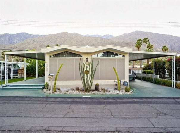 Modern mobile home with desert landscaping and palm trees in Palm Springs.