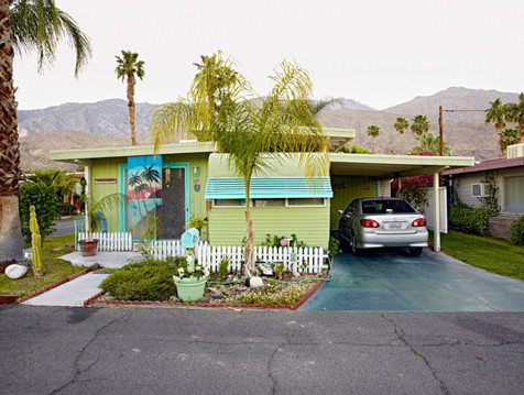 Modern mobile home with desert landscaping and palm trees in Palm Springs.