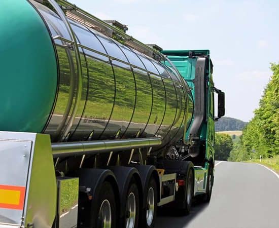 Heavy vehicle transport on a rural road in New Zealand, focusing on driver licensing and training.
