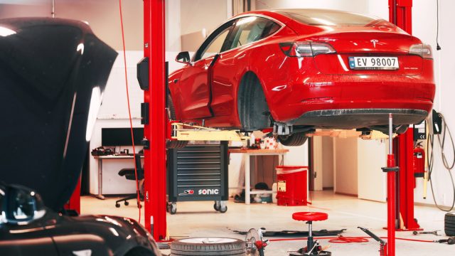 Tesla Service Center Drive-In with Tesla Model S lifted. Tesla workshop in Europe.