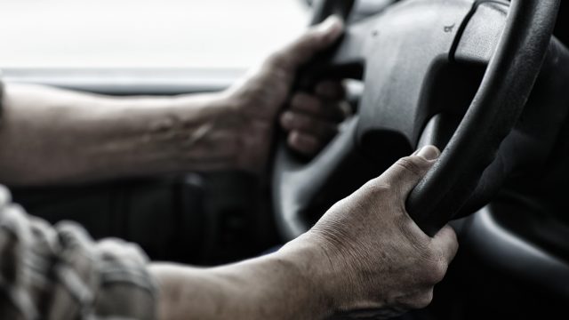 Man holding the steering wheel incorrectly