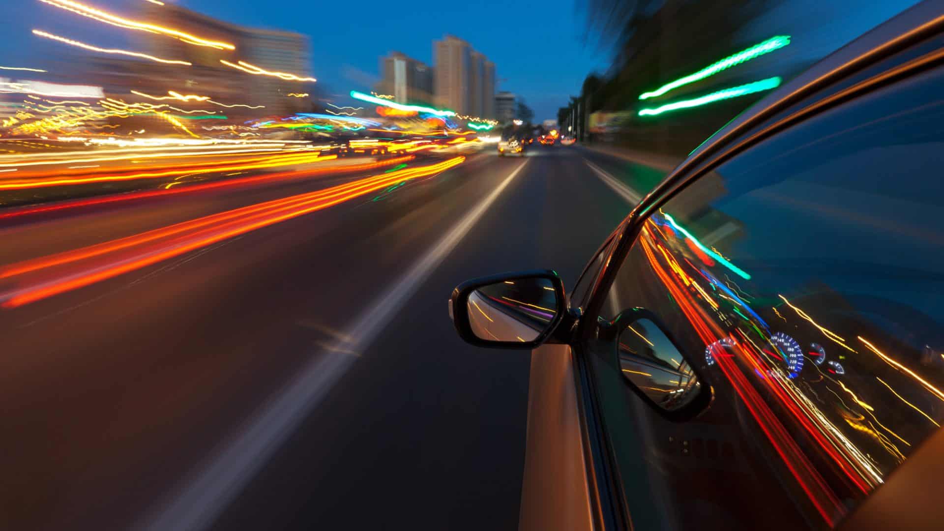 Car driving fast in the night city