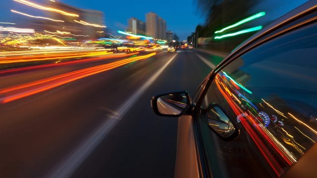 Car driving fast in the night city