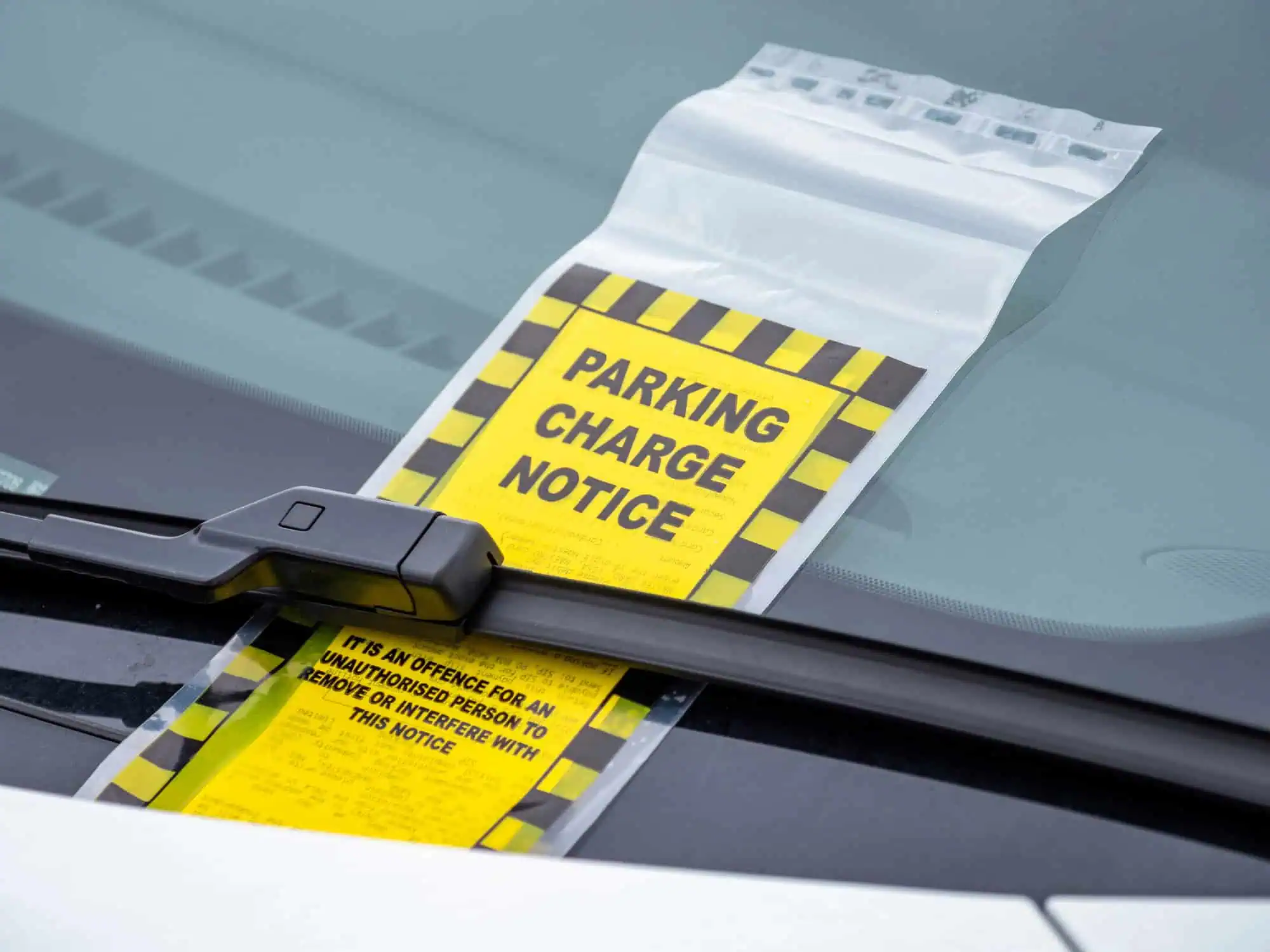 Parking ticket under wind screen wiper of a car