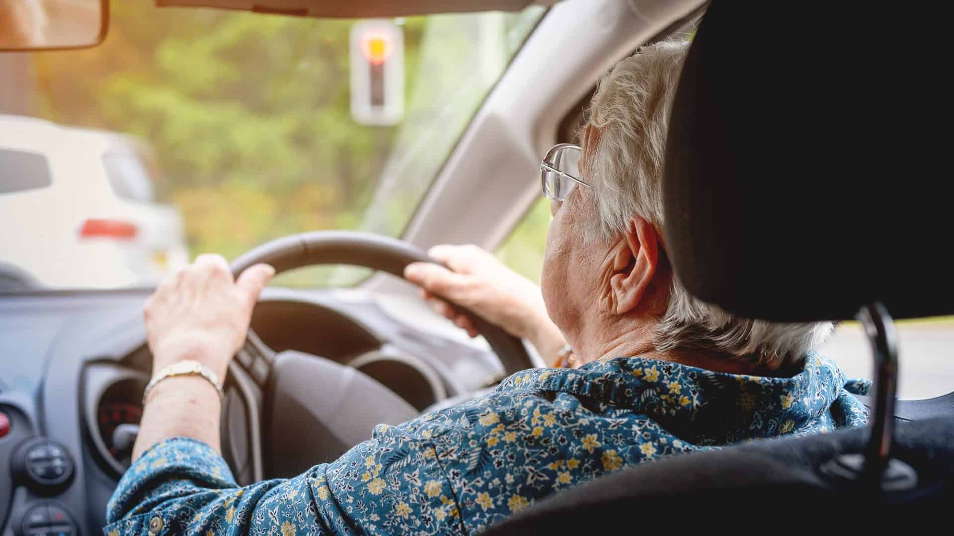 Cheerful senior woman driving a car. Old lady in glasses drive the car in glasses.