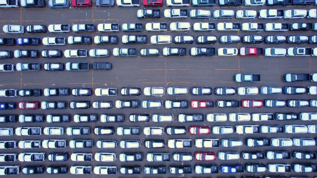 Aerial view of car storage or parking lot with new and used vehicles for export to USA and Internationally. Vehicle transportation facility, waiting to pass customs, duties licenses and permits.