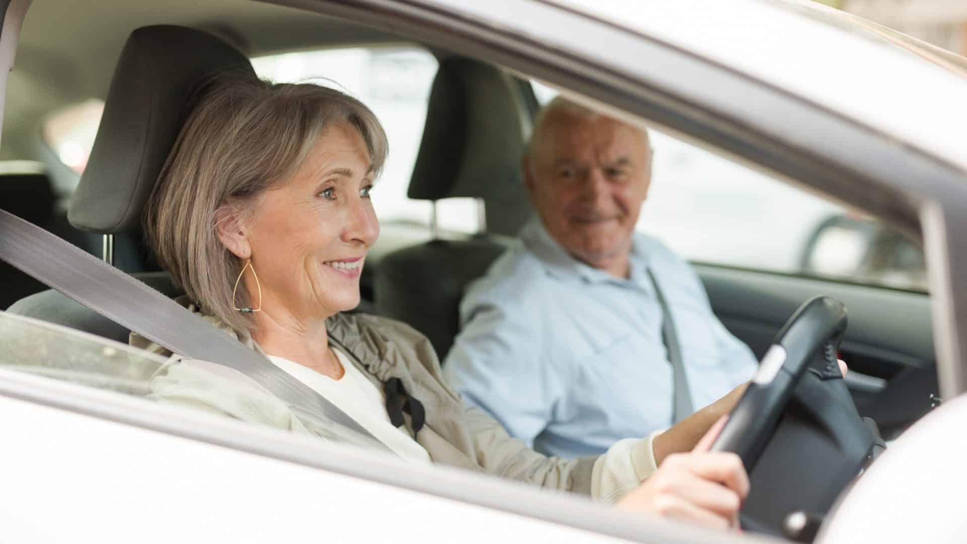 Mature couple sitting in car. Woman sitting at driver's seat.