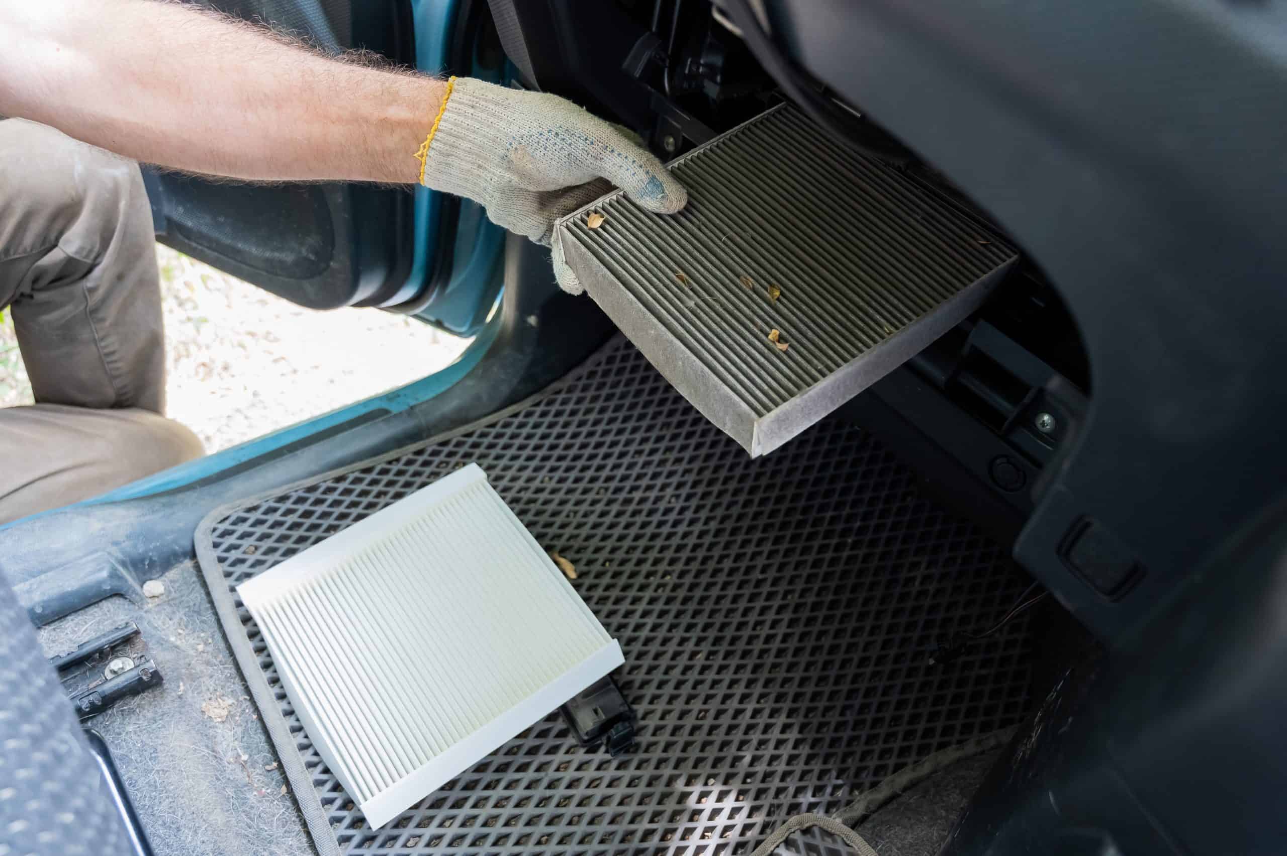 A mechanic changes the cabin air filter of a car