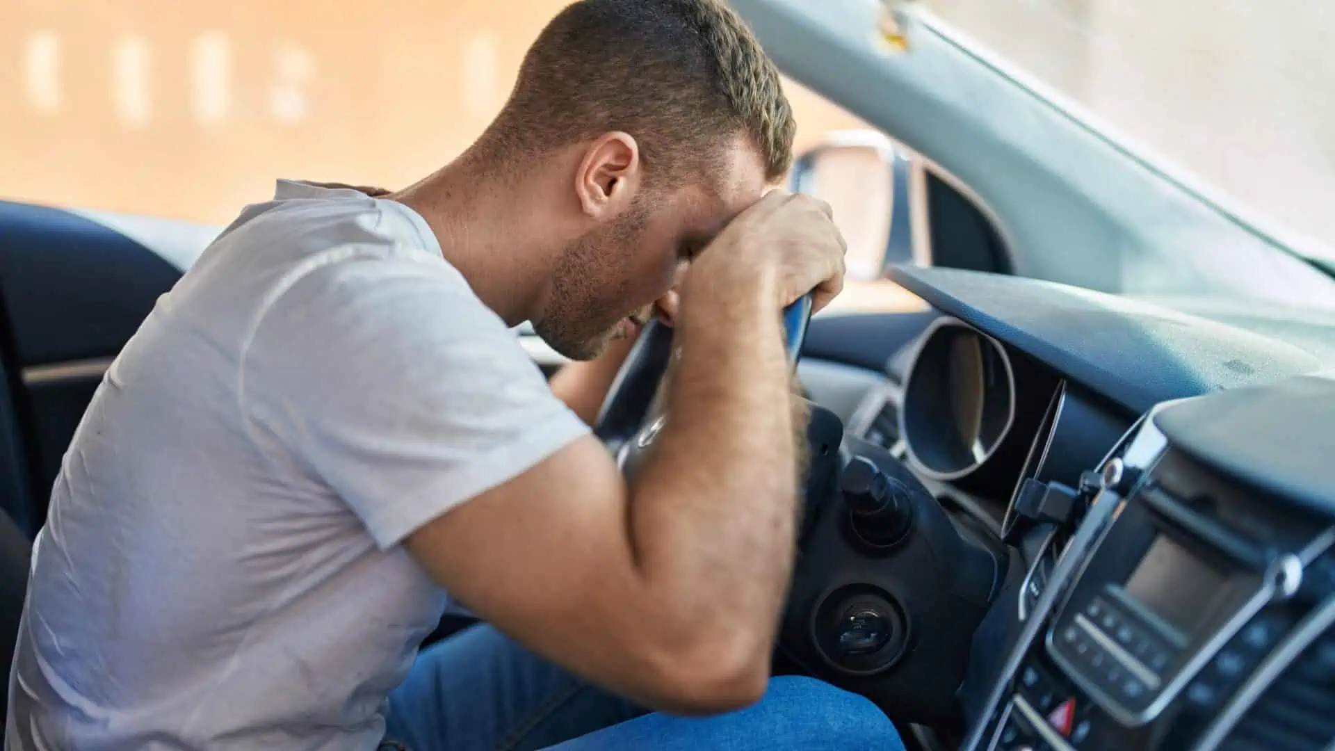 Young caucasian man stressed driving car at street
