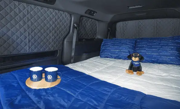 2027 Volkswagen ID. Buzz Tourer pictured with overnight camping accessories and exterior table