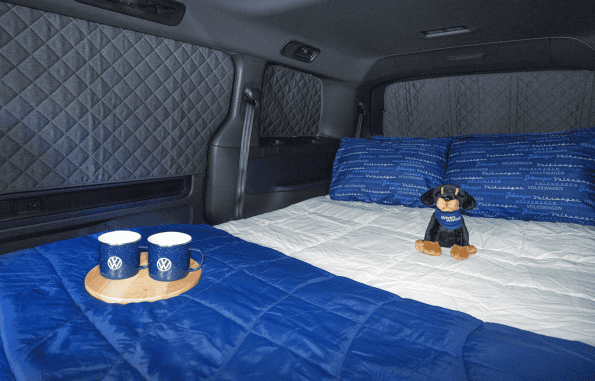 2027 Volkswagen ID. Buzz Tourer pictured with overnight camping accessories and exterior table