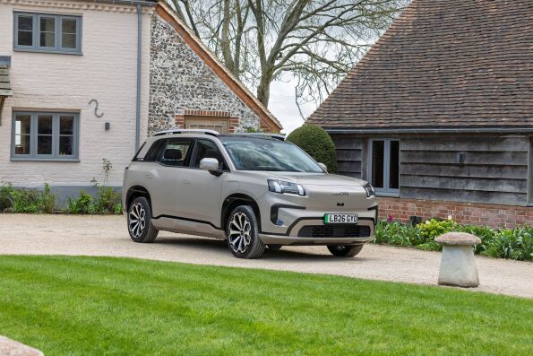 Champagne AION V all-electric SUV parked outside a country house