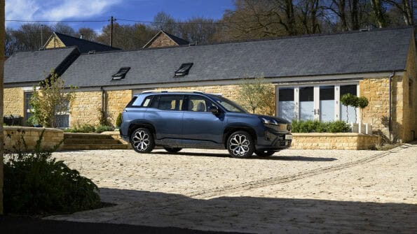 AION V electric SUV parked outside a Cotswold barn