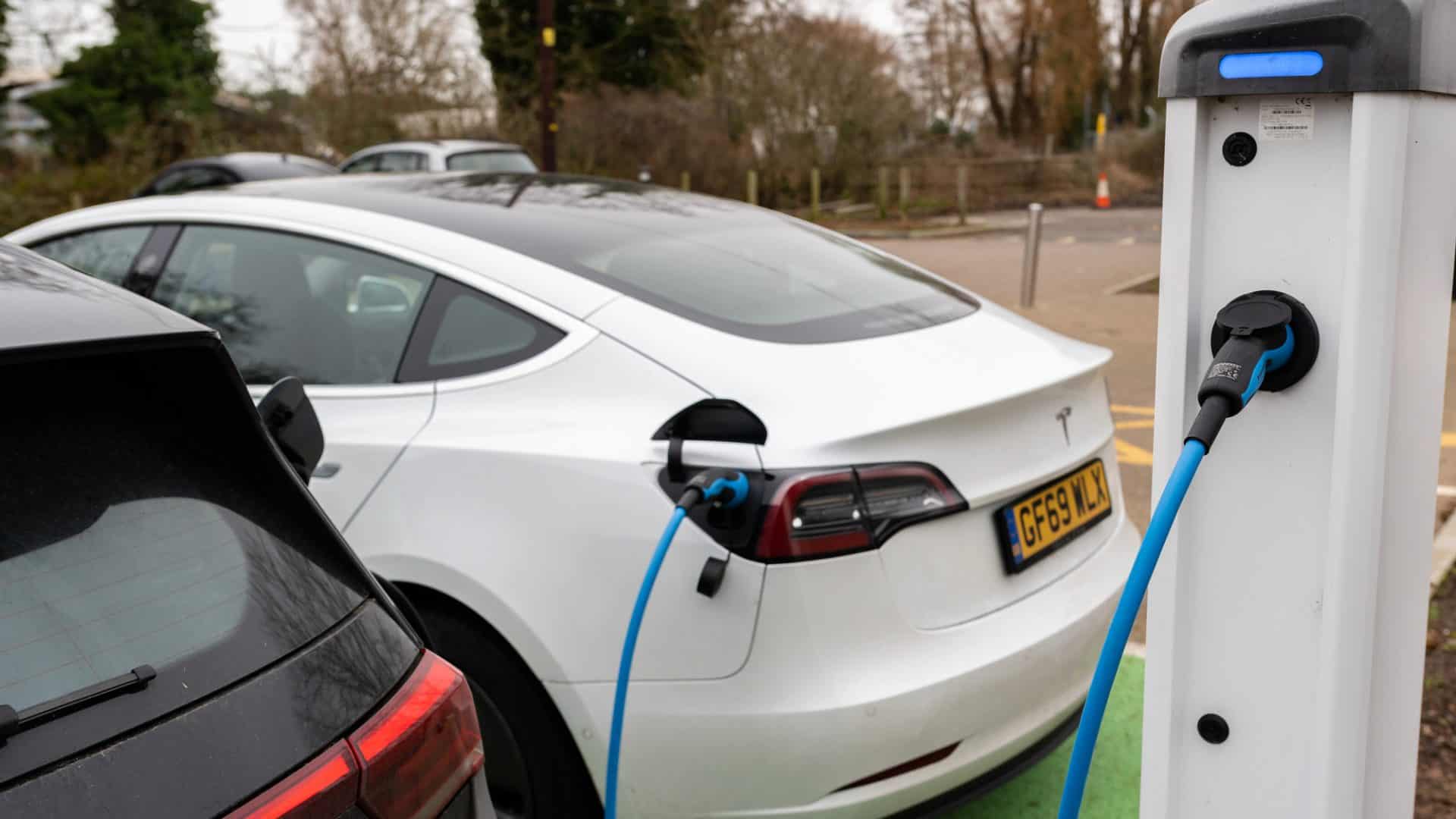 Electric cars charging at plug in charge station in a public car park in Suffolk, UK — Stock Editorial Photography
