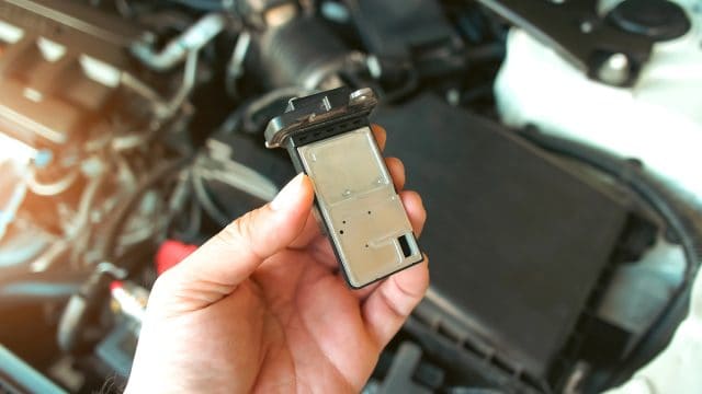 The mass air flow sensor of the engine air intake manifold system in auto mechanic hand, automotive part concept — Photo