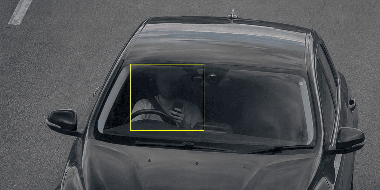 Driver targeted by a camera for using mobile phone while driving