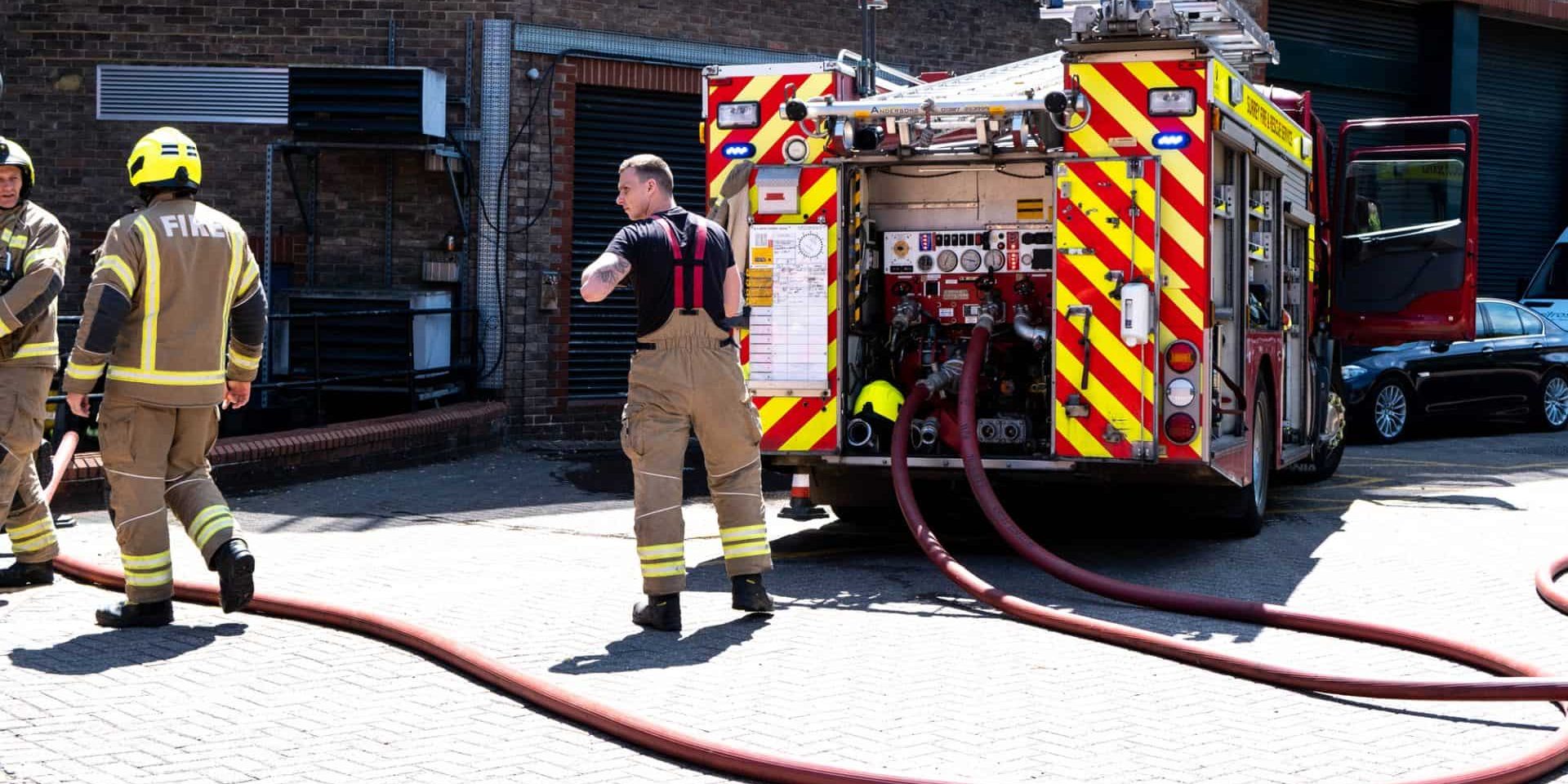 Fire Truck And Fire Fighters Attending A Fire In A Public Car Park