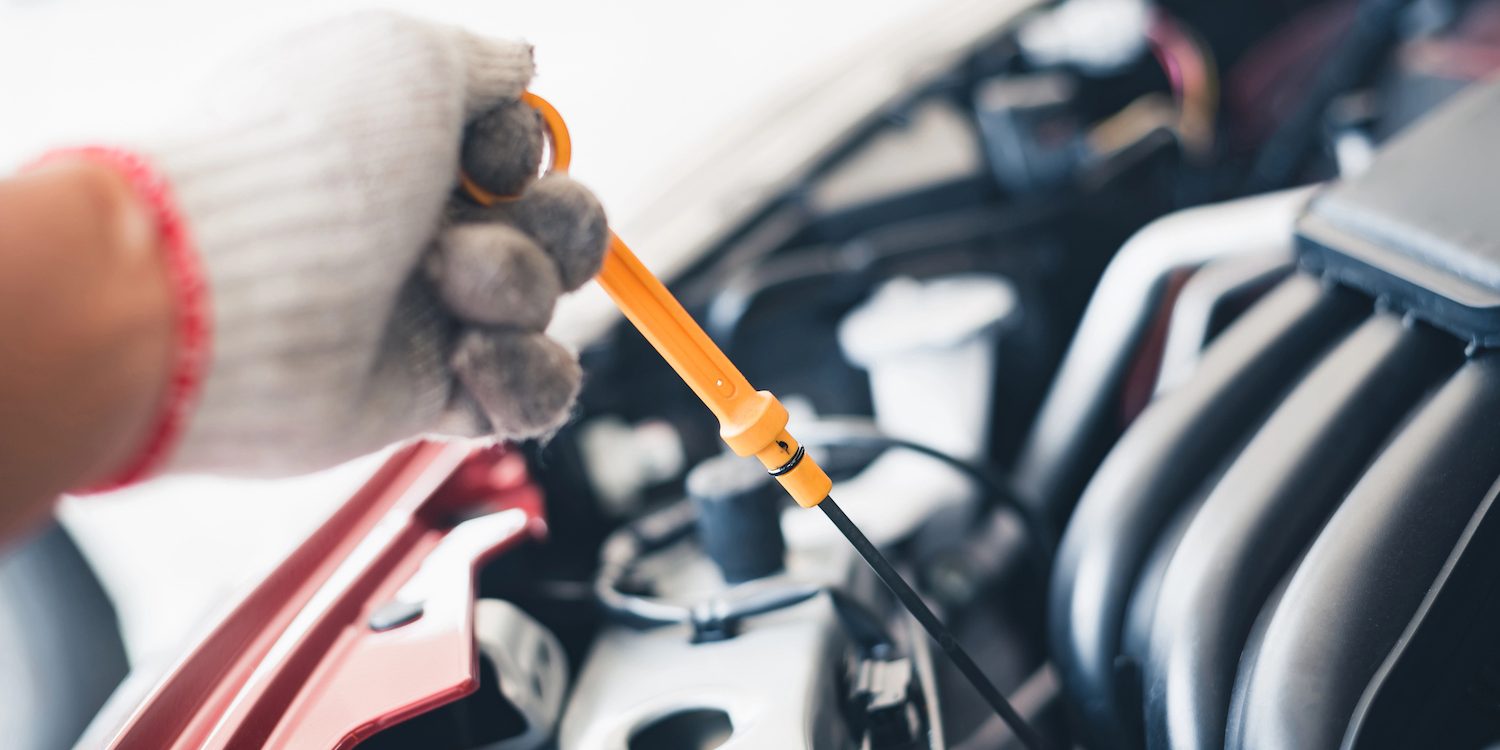 Car mechanic in an auto repair shop is checking the engine. For customers who use cars for repair services, the mechanic will work in the garage.