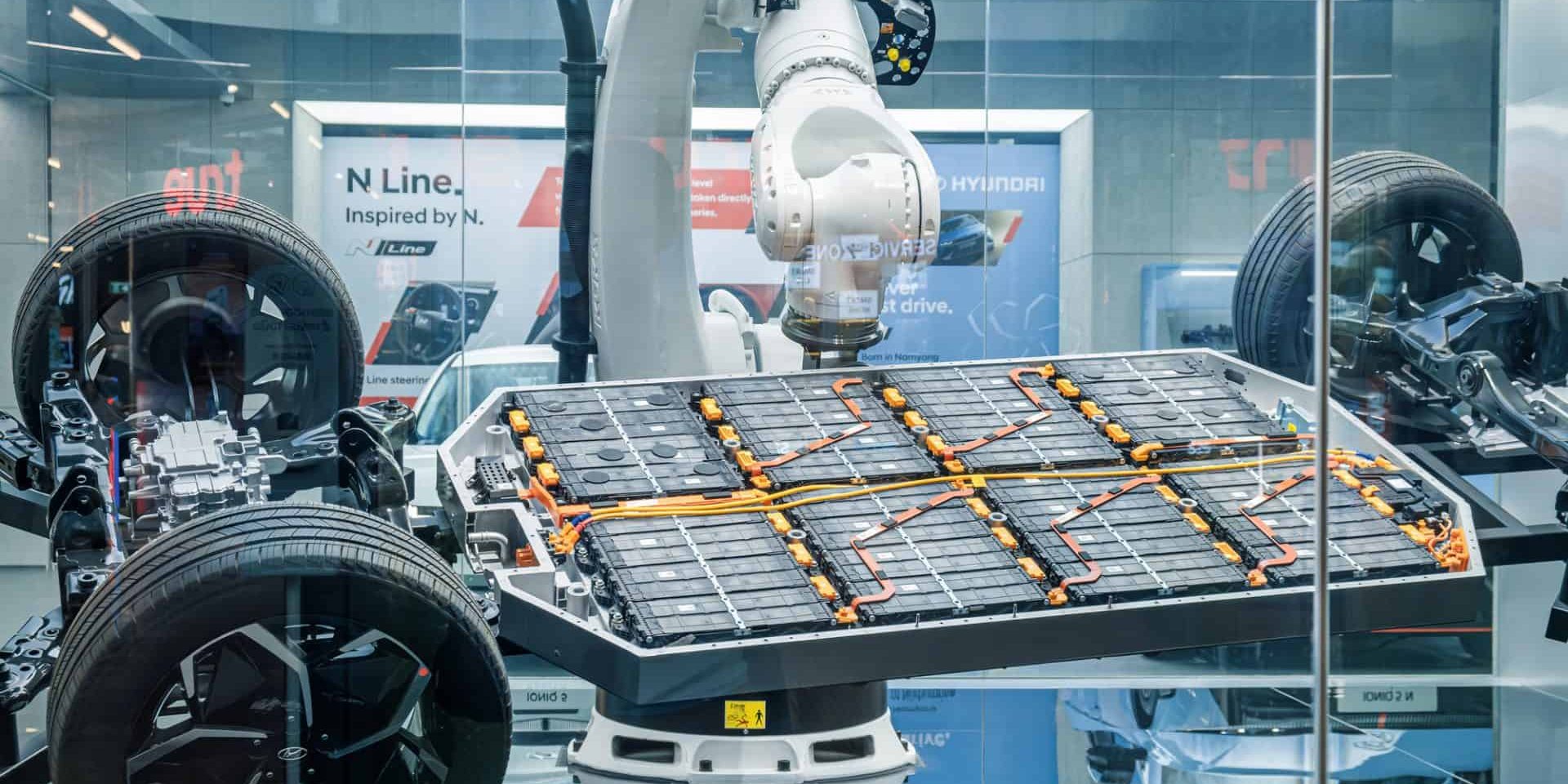 High-tech automotive manufacturing display featuring robotic arms assembling lithium-Ion EV battery pack and demonstrating electric vehicle platform of Hyundai