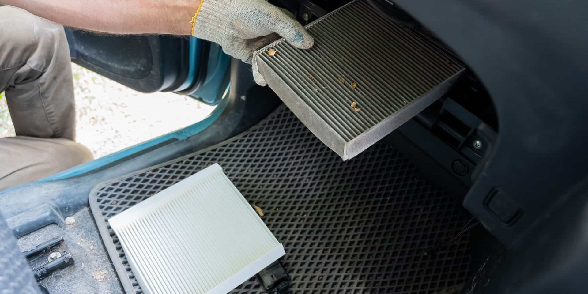 A mechanic changes the cabin air filter of a car