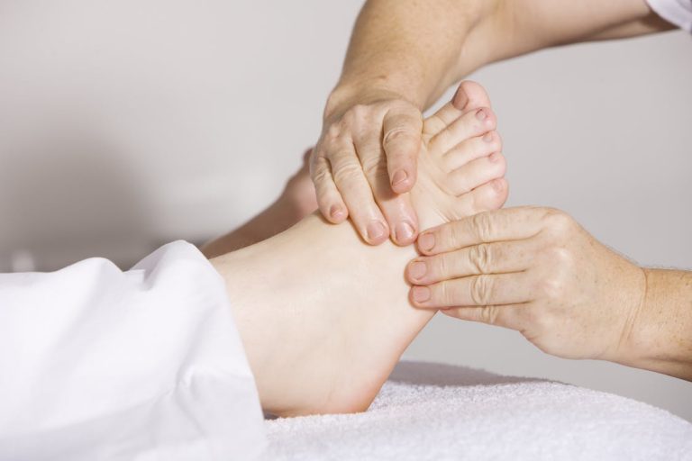 A person experiencing pain relief through manual therapy during a foot massage.