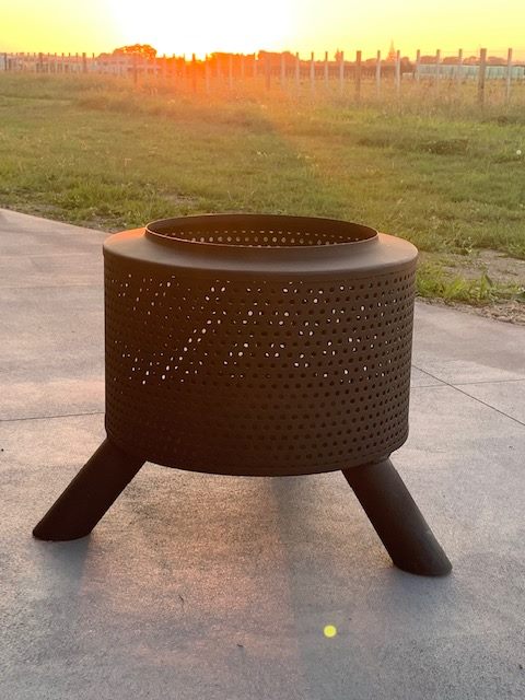 Heavy-duty perforated steel fire pit for outdoor heating and gatherings. Perfect for backyard, camping, or outdoor living spaces.