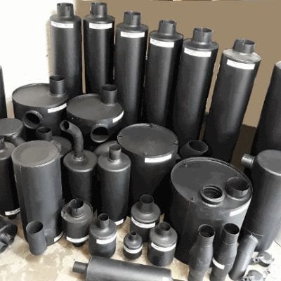 Steel muffler and exhaust part collection for vehicles in a workshop.