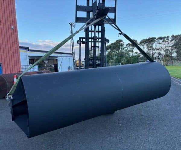 Heavy-duty black muffler being installed on a forklift at Mufflers NZ Ltd workshop.
