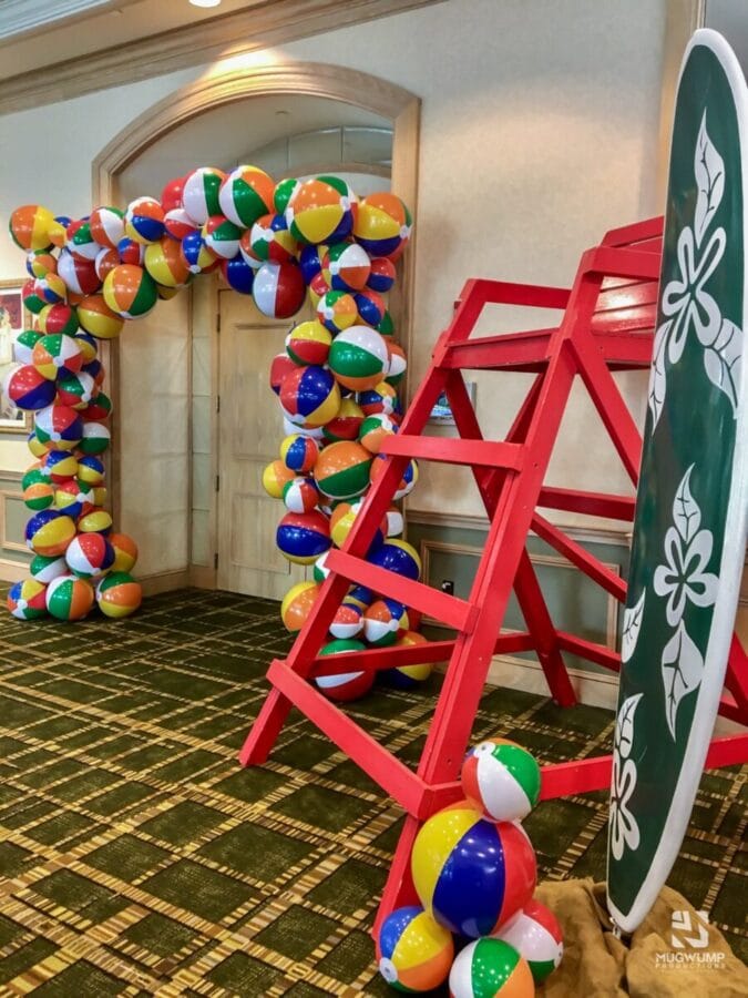 event with a beach ball arch at the entrance and a lifeguard chair next to it