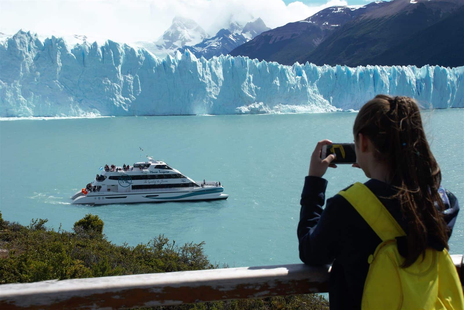 Niña fotografiando el glaciar y el Crucero María Turquesa – Glaciares Gourmet