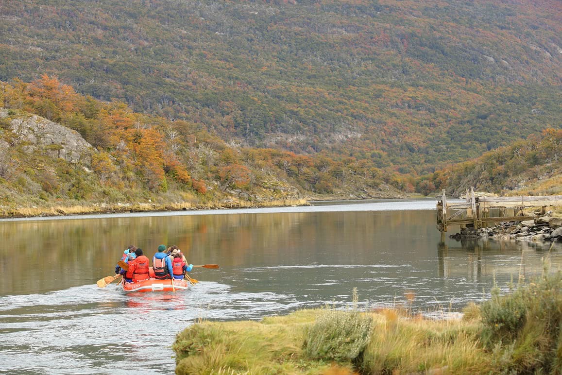 Canoas inflables duckies navegando el río entre el bosque otoñal del Parque Nacional Tierra del Fuego