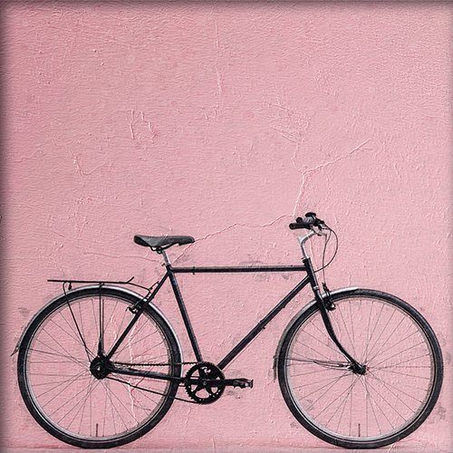 Bicicleta negra sobre fondo rosa