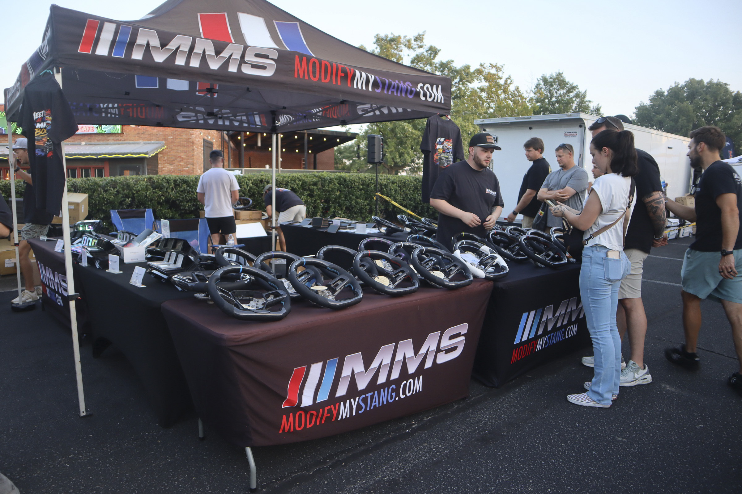 People browsing Mustang car accessories at Mustang Week event.