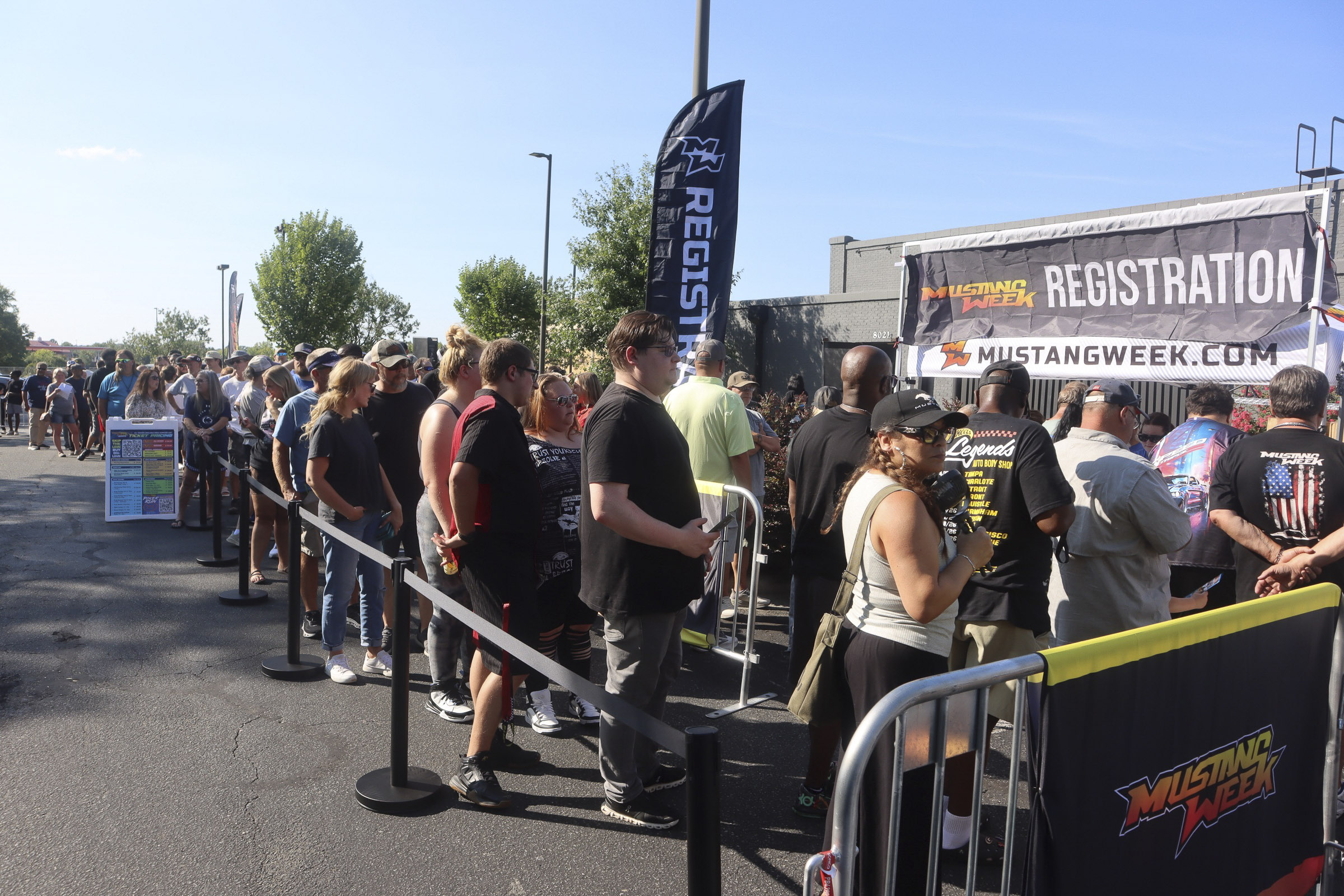 Crowd of people waiting in line at Mustang Week registration booth.