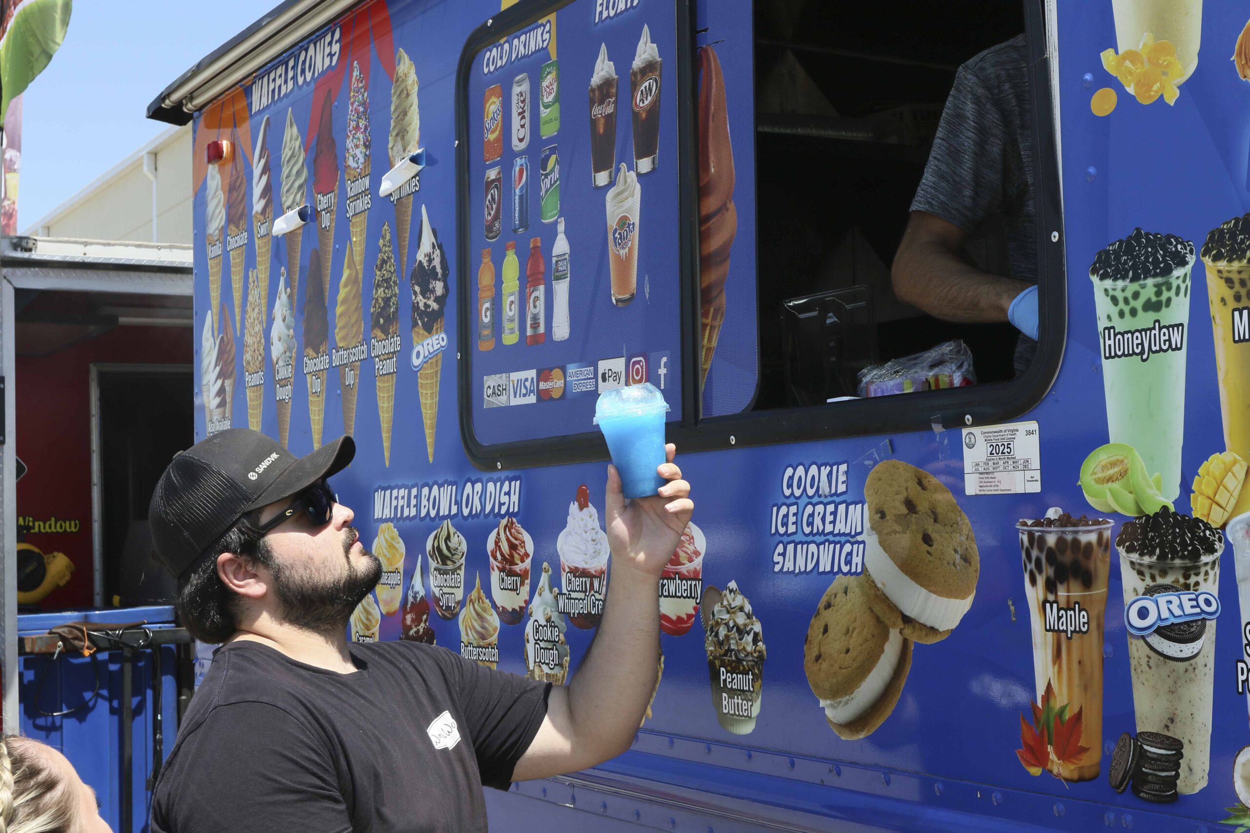 Man enjoying blue cotton candy at Mustang Week food truck.